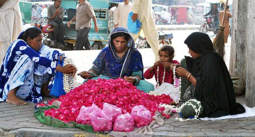 لاہور: محنت کش خواتین پھولوں کے ہار بنا رہی ہیں۔