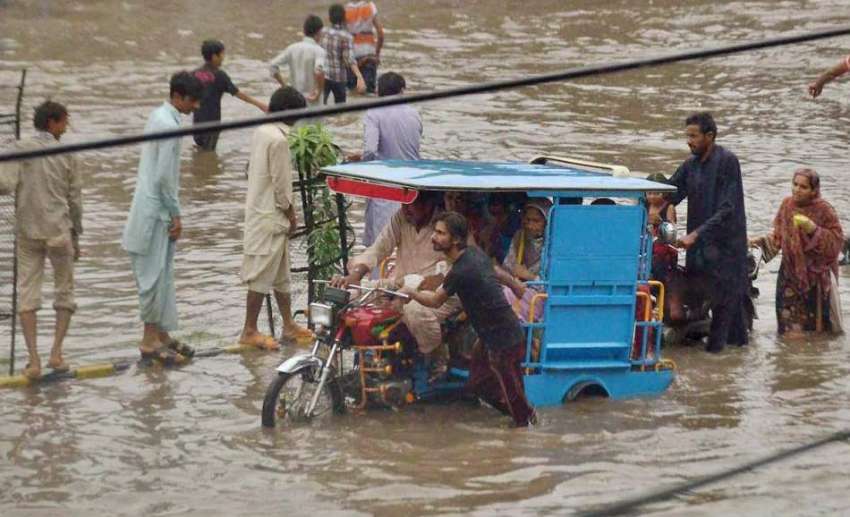 لاہور: ایک ڈرائیور موسلا دھار بارش کے کھڑے پانی میں بند ہونے ..