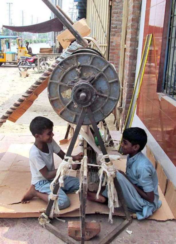 فیصل آباد: دو محنت کش بچے لوم پر کام کر رہے ہیں۔