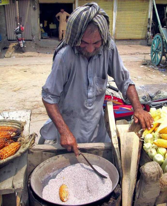 فیصل آباد: ایک معمر شخص فروخت کے لیے چھلیاں تیار کر رہا ہے۔