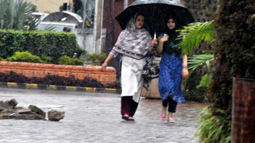 راولپنڈی: خواتین بارش سے بچنے کے لیے چھتری تانے جا رہی ہیں۔
