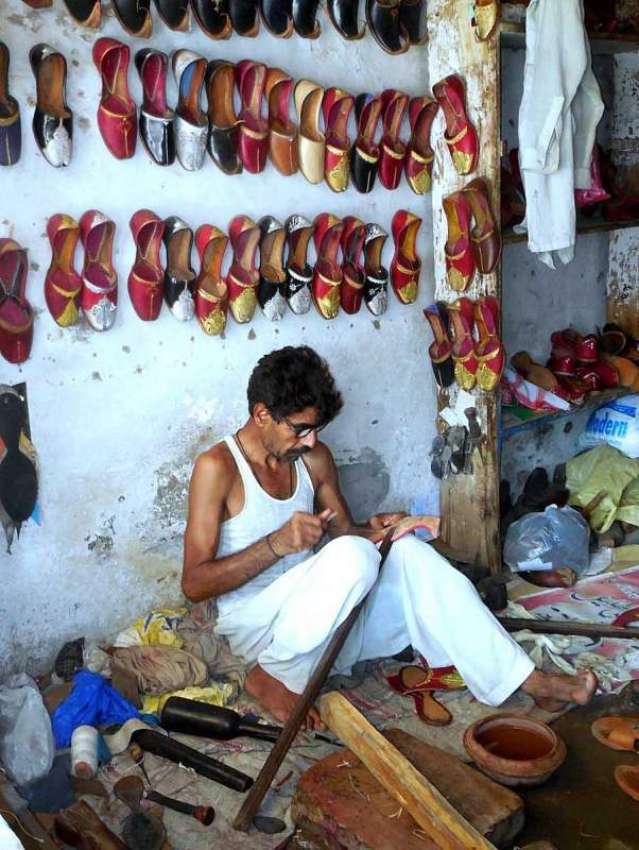 چنیوٹ: محنت کش اپن دکان پر روایتی جوتے بنا رہا ہے۔