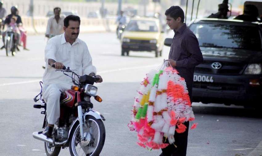 راولپنڈی: ایک محنت کش روڈ کنارے ہار فروخت کرنے کے لیے کھڑا ..