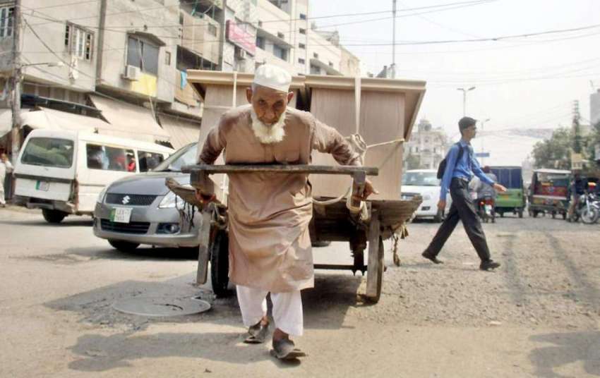 لاہور: ایک بزرگ شخص اپنے خاندان کا پیٹ پالنے کے لیے ہتھ ریڑھی ..