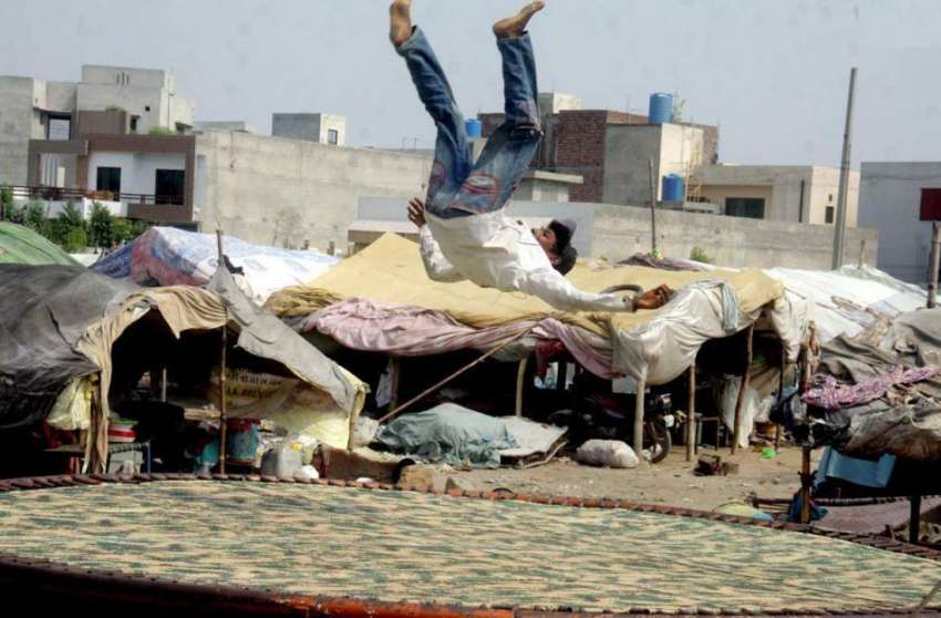 لاہور: جوہر ٹاؤن میں ایک خانہ بدوش لڑکا جمپنگ پیڈ پر کھیل ..