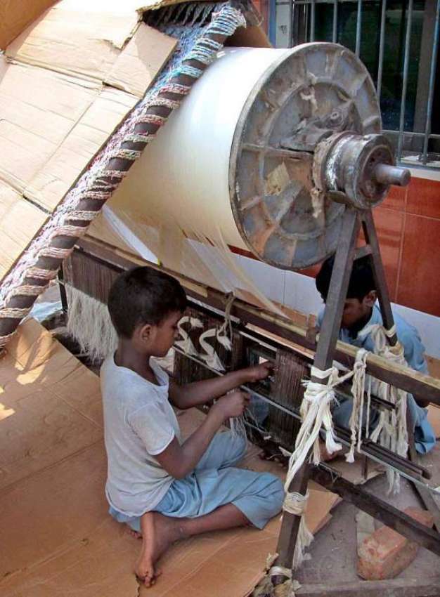 فیصل آباد: محنت کش بچے پاور لوم پر کام میں مصروف ہیں۔