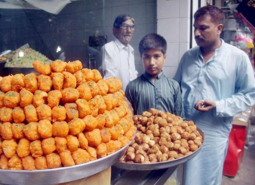 لاہور: ایک شہری دوکان سے مٹھائیاں خرید رہا ہے۔