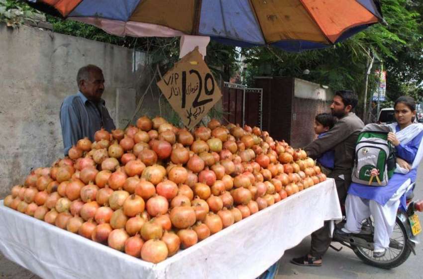 لاہور: ایک ریڑھی بان اپنے ریڑھی پر انار سجائے گاہکوں کا ہکوں ..