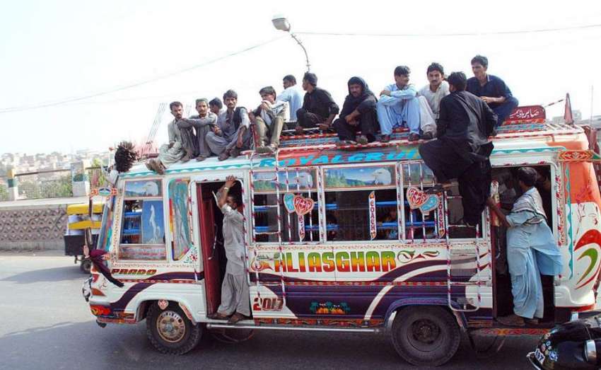 حیدر آباد: شہری بس کی چھت پر سوار ہو کر سفر کر رہے ہیں جو کسی ..