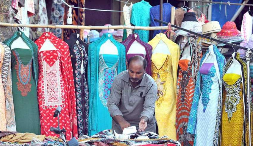 اسلام آباد: دوکاندار اپنی دوکان کے باہر فروخت کے لیے کپڑے ..