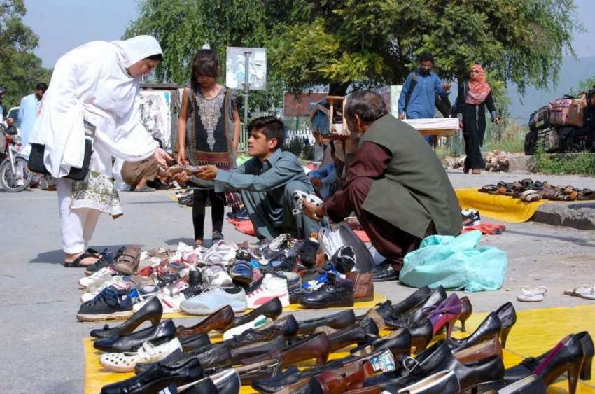 اسلام آباد: ایک خاتون روڈ کنارے لگے سٹال سے جوتے پسند کر ..