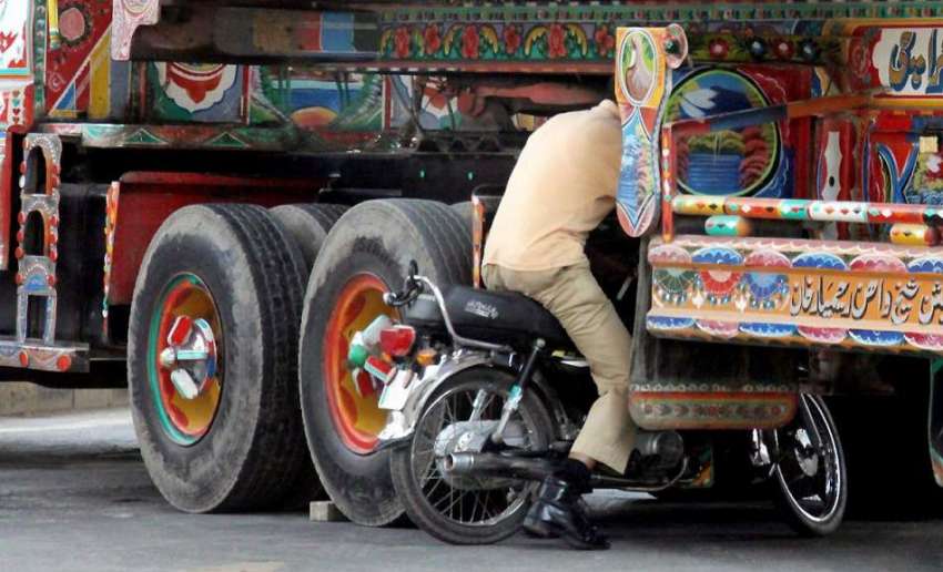 لاہور: ایک موٹر سائیکل سوار محرم الحرام کے مرکزی جلوس کی ..