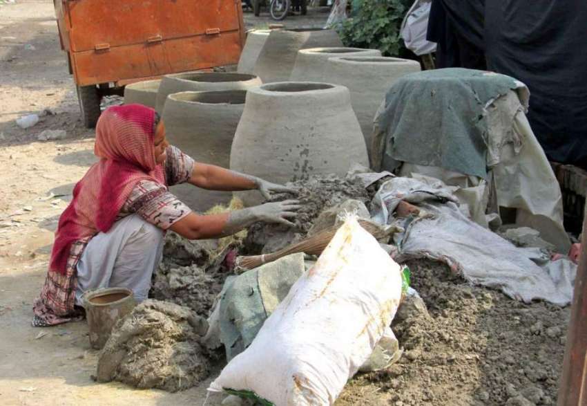 فیصل آباد: محنت کش خاتون تندور بنانے میں مصروف ہے۔