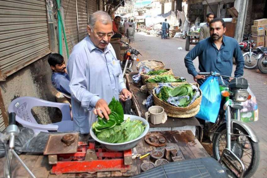 لاہور: ایک بزرگ محنت کش اپنی دوکان پر پان کے پتے فروخت کر ..