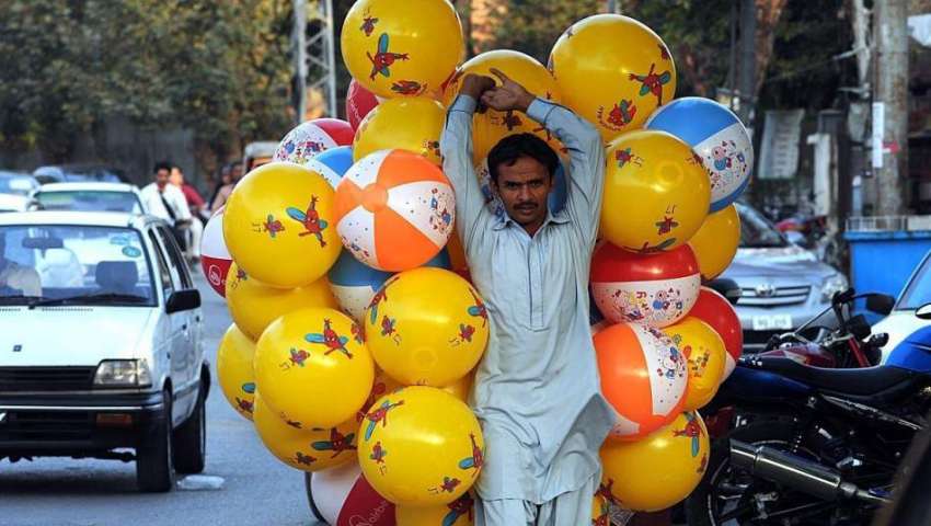 راولپنڈی: محنت کش مختلف رنگوں والے پلاسٹک کے بال فروخت کر ..