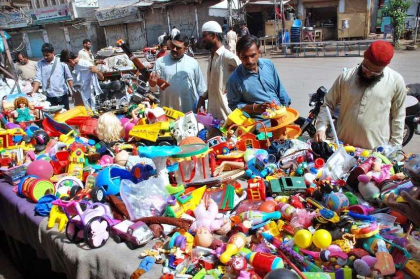 حیدر آباد: سڑک کنارے لگے سٹال سے شہری کھلونے خرید رہے ہیں۔