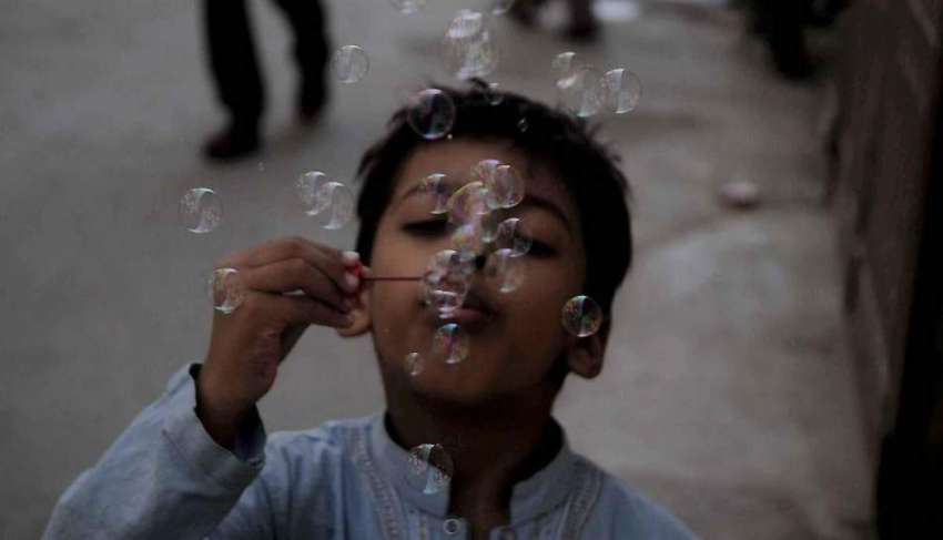 راولپنڈی: راہ چلتے ایک بچہ بلبلے اڑانے میں مصروف ہے۔