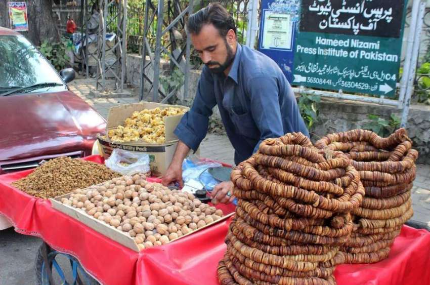 لاہور: ریڑھی بان ڈرائی فروٹ فروخت کر رہا ہے۔