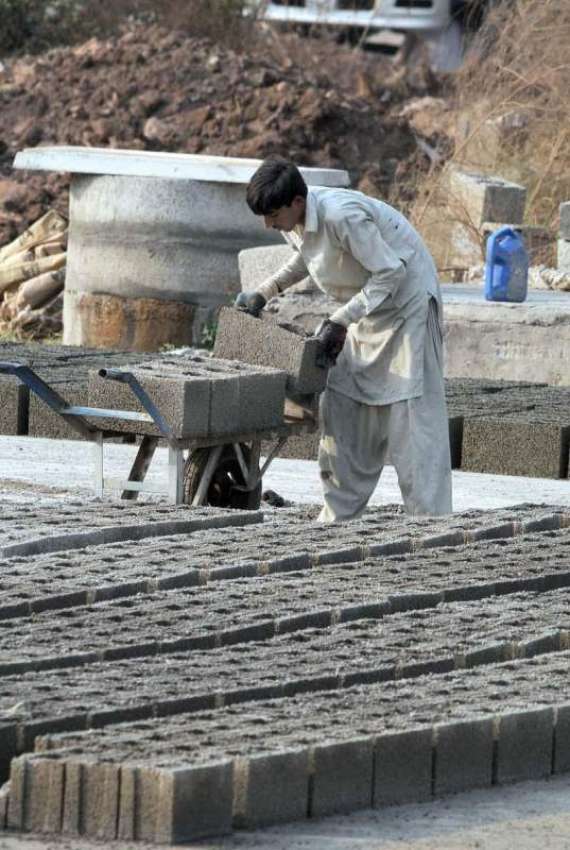 اسلام آباد: مزدور سیمنٹ سے بنے بلاک ہتھ ریڑھی میں رکھ رہا ..