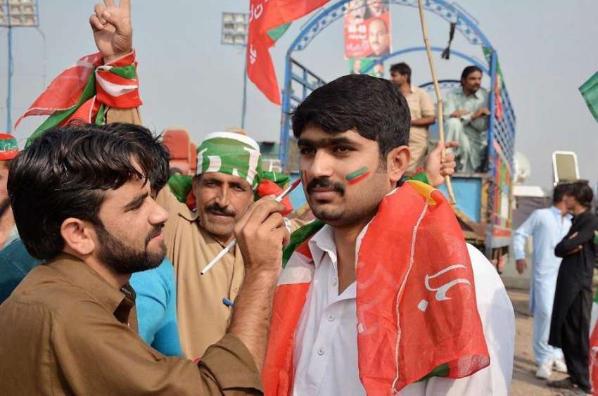 اسلام آباد: پی ٹی آئی کا کارکن اپنے چہرے پر پینٹنگ بنوا رہا ..