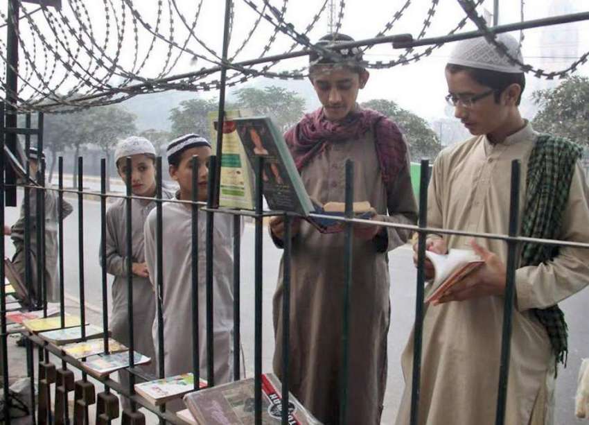 لاہور: مدرسے کے طلباء سڑک کنارے لگے سٹال سے کتابوں کا معائنہ ..