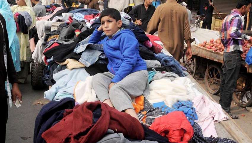 رالپنڈی: ہفتہ وار جمعہ بازار میں ایک بچہ کپڑے فروخت کرنے ..