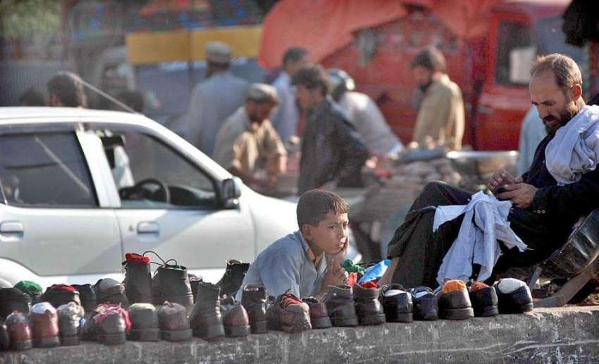 اسلام آباد: ایک بچہ پرانے جوتے فروخت کرنے کے لیے گاہکوں کے ..