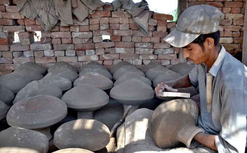 حیدر آباد: مزدور مٹی سے بنائے گئے برتنوں کو فائنل ٹچ دے رہا ..
