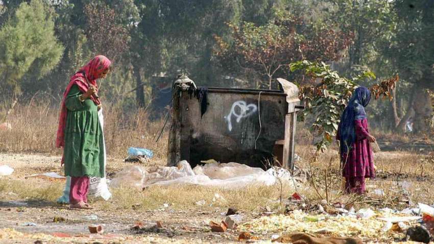 اسلام آباد: خانہ بدوش خاتون اپنی بچی کے ہمراہ کچرے کے ڈھیر ..