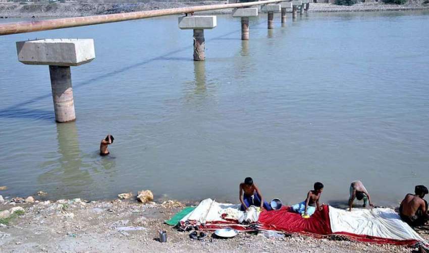 حیدر آباد: خانہ بدوش افراد نہر کنارے کپڑے دھو رہے ہیں۔