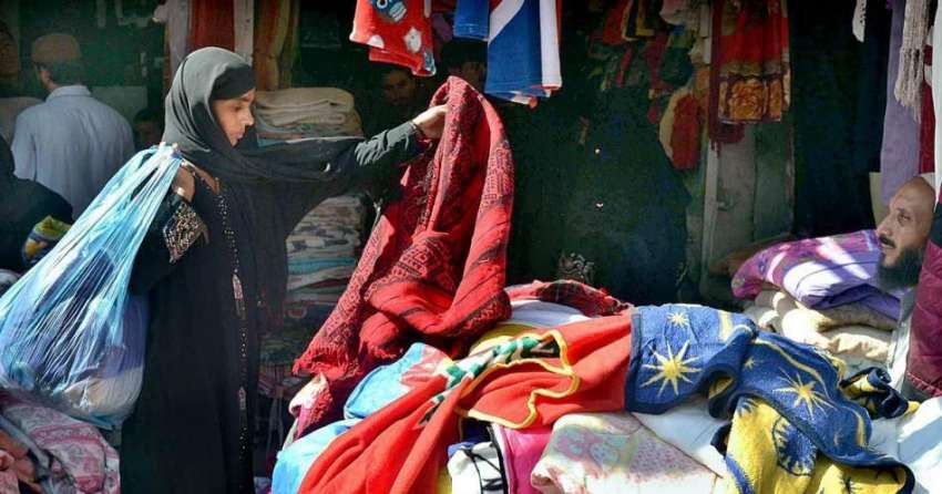 حیدر آباد: سڑک کنارے لگے سٹال سے ایک خاتون کپڑے پسند کر رہی ..