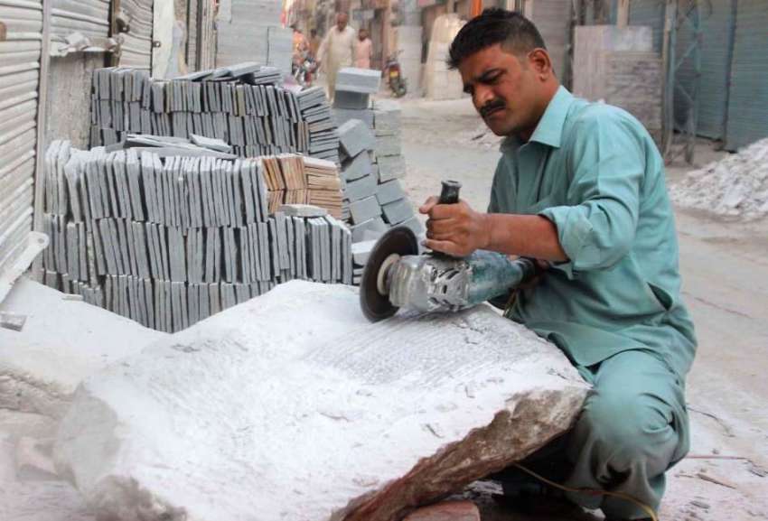 لاہور: مزدور کٹر کے ذریے ماربل کاٹ رہا ہے۔