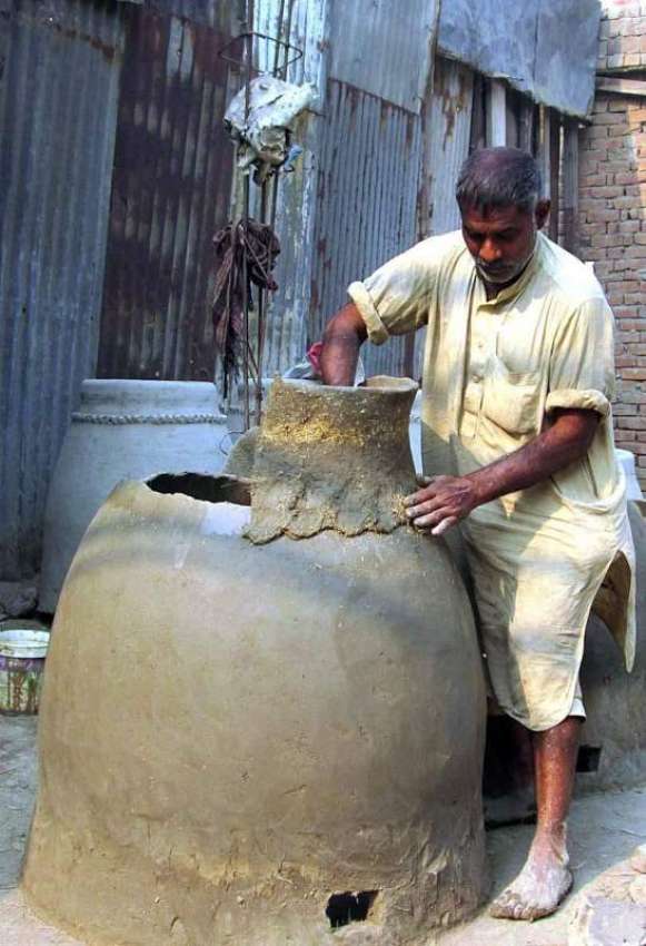 فیصل آباد: کمہار رواتی تندور بنانے میں مصروف ہے۔