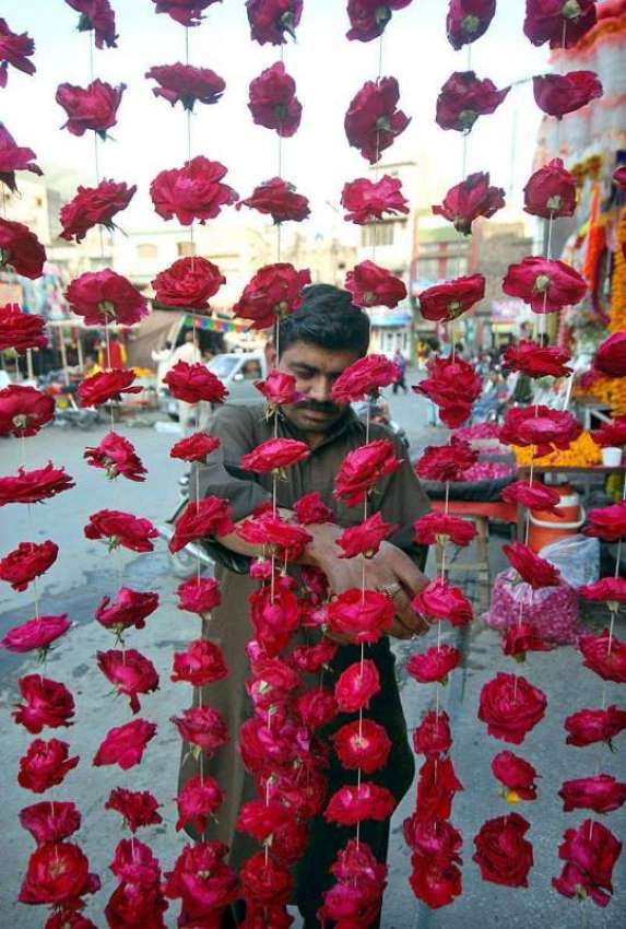 راولپنڈی: دکاندار فروخت کے لیے پھول سجا رہا ہے۔