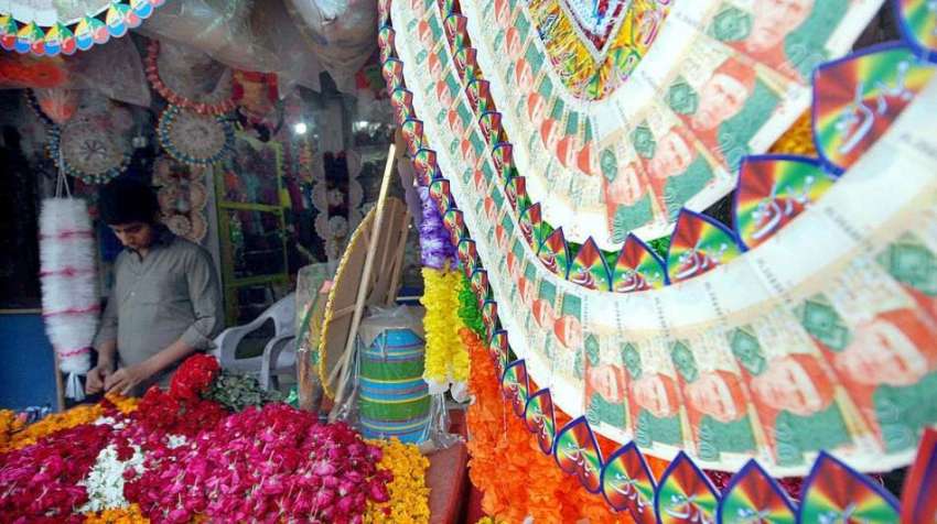 راولپنڈی: دکاندار فروخت کے لیے پھول سجا رہا ہے۔