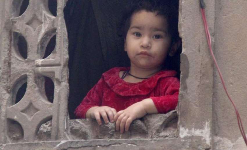 لاہور: گڑھی شاہوں کے علاقہ میں ایک بچی کھڑکی سے باہر جھانک ..