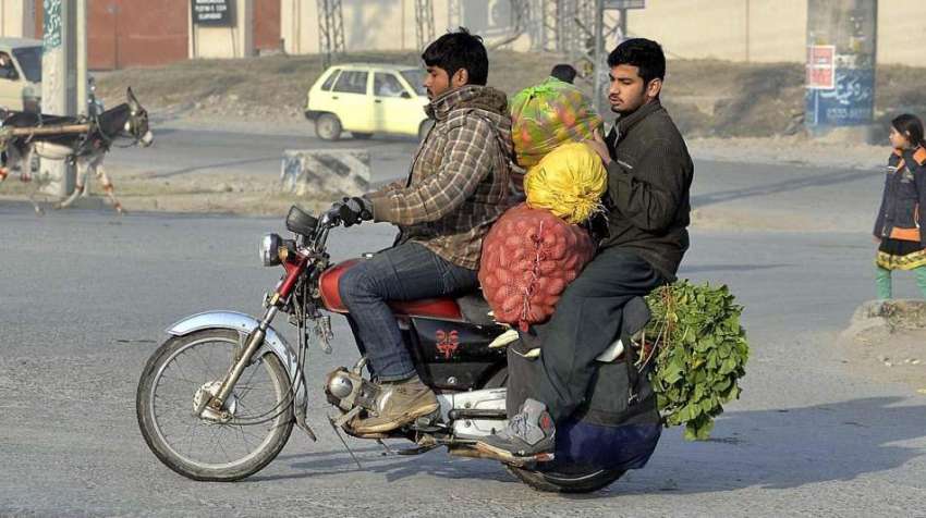 راولپنڈی: دوموٹر سائیکل سوار موٹر سائیکل پر سبزی لادھے جارہے ..