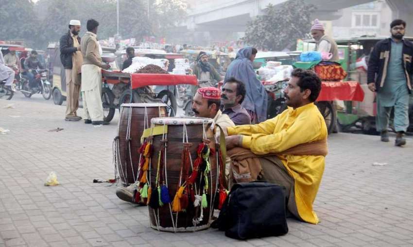 لاہور: ڈھولچی گاہکوں کے انتظار میں سڑک کنارے بیٹھے ہیں۔