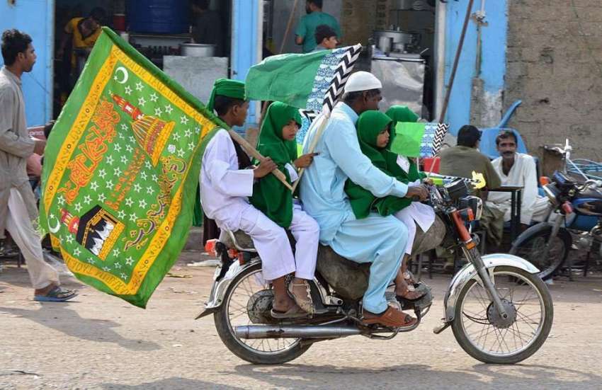کراچی: موٹر سائیکل سوار اپنے بچوں کے ہمراہ عید ملادالنبی ..