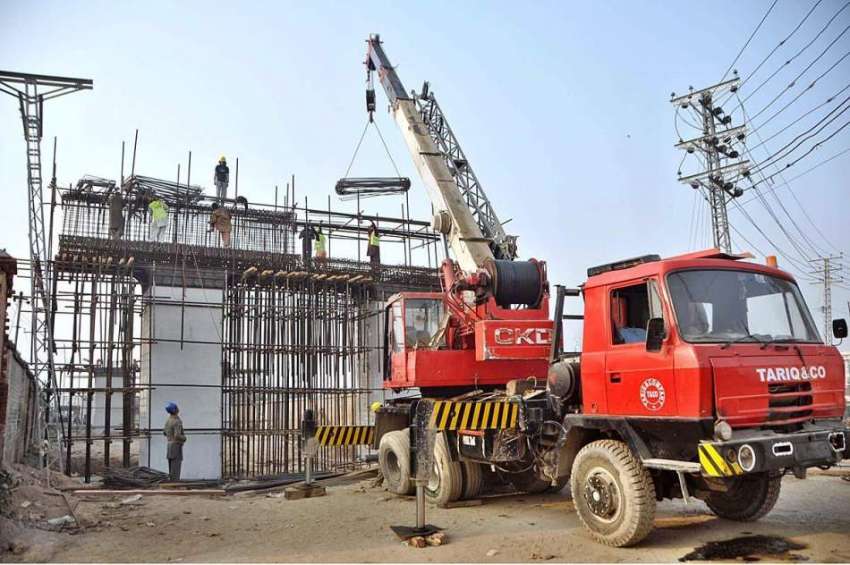 لاہور: کچا جیل روڈ پر زیر تعمیر فلائی اوور پر مزدور کام میں ..