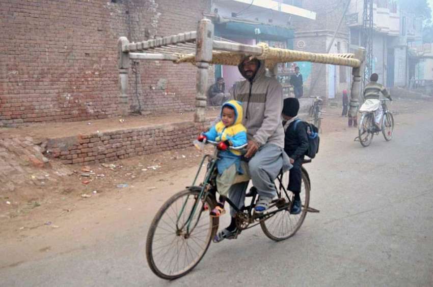 ملتان: ایک سائیکل سوار اپنے بچوں کے ہمراہ سر پر چارپائی اٹھائے ..