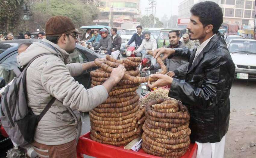 لاہور: ایک شہری ریڑھی بان سے انجیر خرید رہا ہے۔