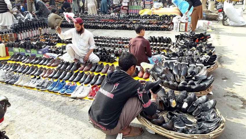 راولپنڈی: محنت کش سڑک کنارے فروخت کے لیے جوتوں کا سٹال لگائے ..