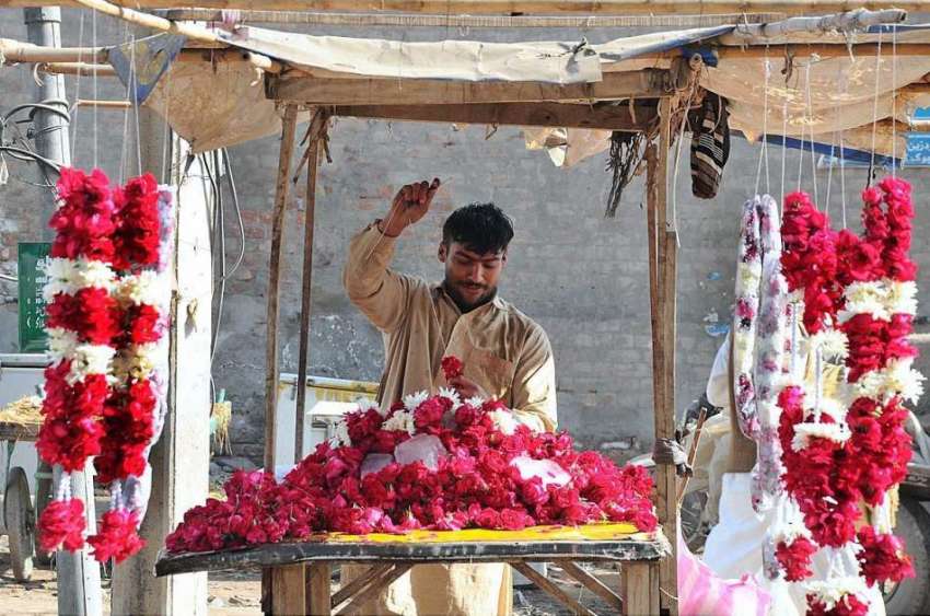 ملتان: دکاندار پھولوں کی چادر بنانے میں مصروف ہے۔