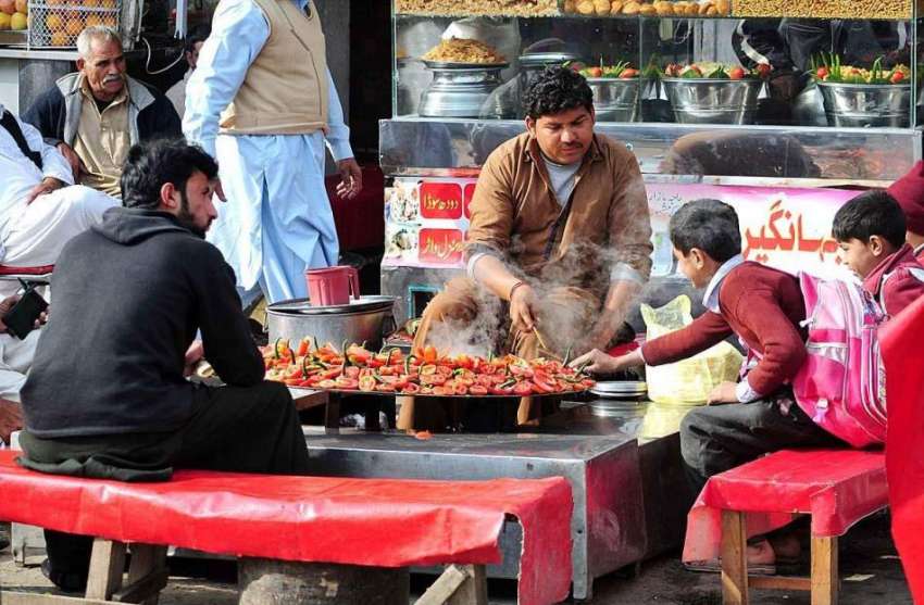 راولپنڈی: دکاندار سڑک کنارے روایتی انداز سے کھانا بنا کر ..