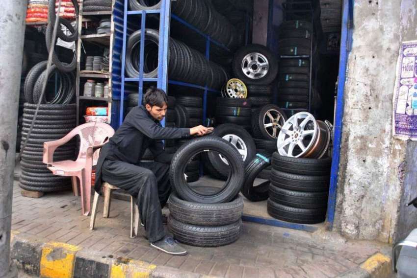 لاہور: ایک دکاندار گاڑی کے پرانے ٹائر صاف کرنے میں مصروف ..