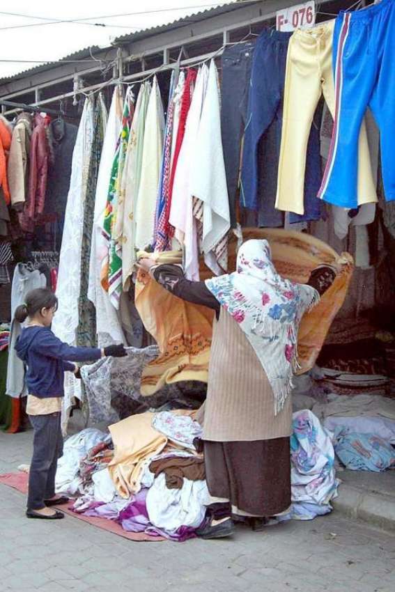 اسلام آباد: ایک خاتون اپنی بچی کے ہمراہ کپڑا پسند کر رہی ..