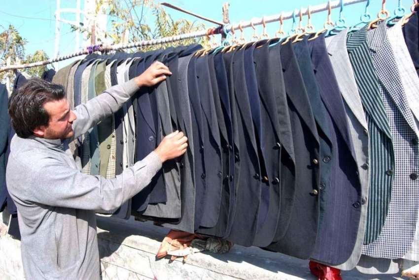 اسلام آباد: ایک دکاندار سڑک کنارے فروخت کے لیے گرم کوٹ ڈسپلے ..