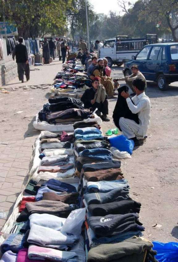 اسلام آباد: ایک شخص سڑک کنارے گرم کپڑے لگائے گاہکوں کا منتظر ..