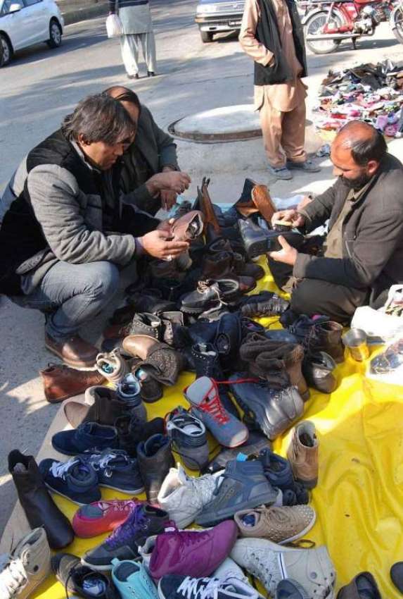 اسلام آباد: سڑک کنارے لگے سٹال سے شہری پرانے جوتے پسند کر ..